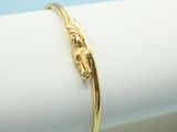 a close up of a gold bracelet on a white napkin