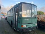 un bus vert garé à côté d'une remorque