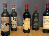 several bottles of wine are lined up on a wooden shelf