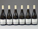 six bouteilles de vin sont alignées sur une table