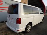 the rear end of a white van parked in front of a building