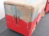 an old red and blue toy truck with wheels on the floor