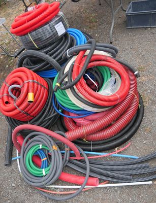 a pile of hoses sitting on the ground next to other hoses