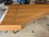 a wooden table with a piano on it in a room