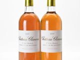 two bottles of wine sitting next to each other on a white surface