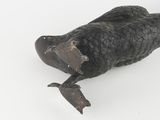 a black sculpture of a fish on a white surface