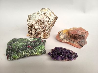 trois types différents de roches et de cristaux sur une surface blanche