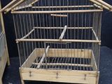 a bird cage with a bird in it next to a bed