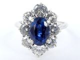 un gros plan d'une bague sertie d'un saphir bleu entouré de diamants
