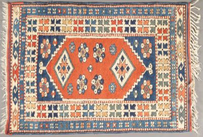 un tapis orange, bleu et blanc à motifs en losanges