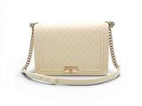 un sac à bandoulière Chanel en cuir matelassé beige, avec des finitions dorées
