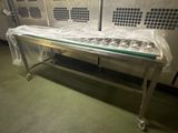 un banc en métal avec un plateau en verre, placé au milieu d'une pièce