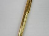 an image of a gold pen on a white surface