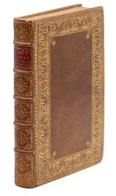 un vieux livre à la couverture brune et à la bordure dorée