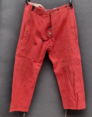 un vieux pantalon rouge suspendu à un portant