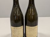 deux bouteilles de vin posées sur une table l'une à côté de l'autre