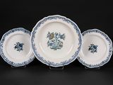trois assiettes bleues et blanches ornées de fleurs sur un fond noir