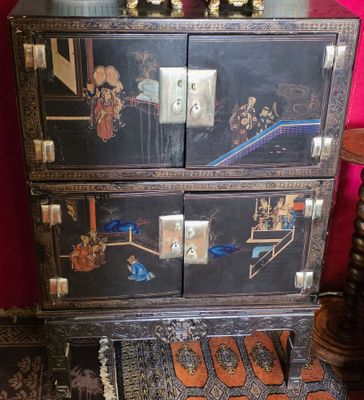une commode noire ornée d'une peinture