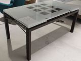 une table avec un plateau en verre et des pieds en métal