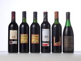six bottles of wine are lined up in a row on a table