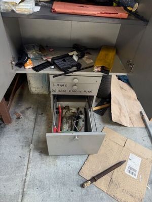 une photo d'un espace de travail en désordre avec un tiroir rempli d'outils
