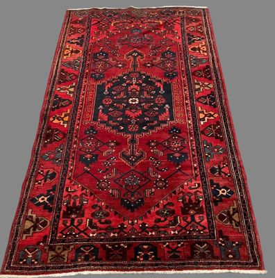 a red and black rug with a medallion design on it