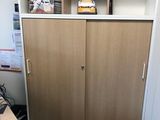 a desk with a computer and a cabinet in the corner of the room
