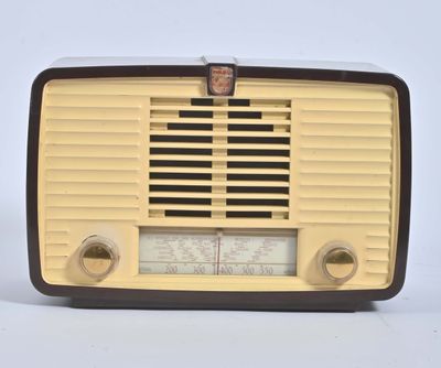 une radio à l'ancienne posée sur un meuble blanc