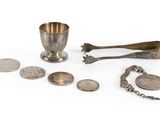 a group of silver objects including a spoon, spoon and spoon rest