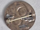 an image of a silver broochle with a stick sticking out of it