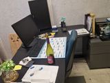 a desk with a computer and a bottle of wine on it