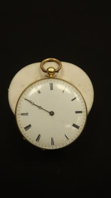 a small white clock with roman numerals on it