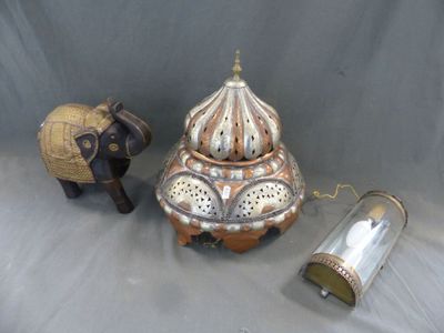 un petit éléphant à côté d'un vase et une figurine d'éléphant posée sur une table