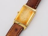 an image of a gold watch with a brown leather strap