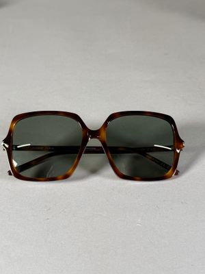 une paire de lunettes de soleil posée sur une surface blanche