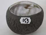 a small bowl with a sticker on it on a table