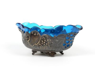 une image représentant un bol en verre bleu posé sur un socle en métal