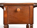a small wooden table with a drawer on it