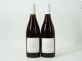 deux bouteilles de vin posées l'une à côté de l'autre sur une surface blanche