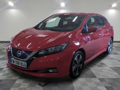 La Nissan Leaf rouge est garée sur un sol à damier.