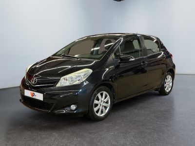 La Toyota Yaris noire est garée dans une grande pièce.