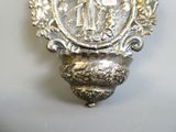 a silver plate with a picture of a woman and a snake on it