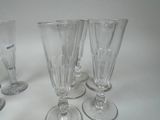 several empty wine glasses are lined up on a white surface