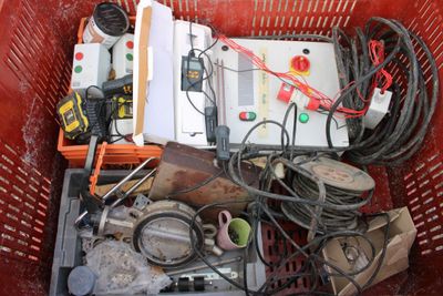a red basket filled with assorted electrical equipment