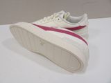white and pink puma sneakers on a white surface with a white background