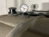 a close up of a bathroom sink with a thermometer on it