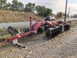 an image of a tractor plow parked on the side of the road
