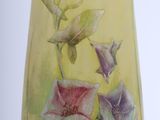 a glass vase with flowers painted on it on a table