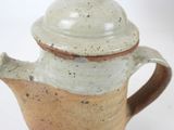 a brown and white tea pot with a lid