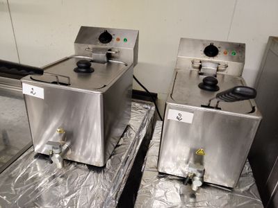 deux friteuses en acier inoxydable posées sur une tôle